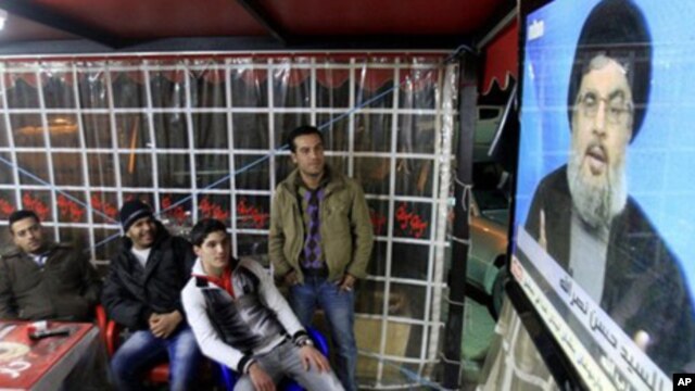 People watch the speech of Hezbollah leader Hassan Nasrallah on a screen at a cafe in the southern port city of Sidon, Lebanon, Sunday, Jan. 16, 2011.