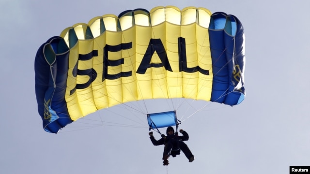 A U.S. Navy SEAL, who is a member of the Navy parachute team 'Leap Frogs', takes part in a demonstration of combat skills at the National Navy UDT-SEAL Museum in Fort Pierce, Florida, November 11, 2011. 