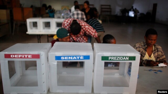 FILE - Haitian workers from the Provisional Electoral Council organize ballots.
