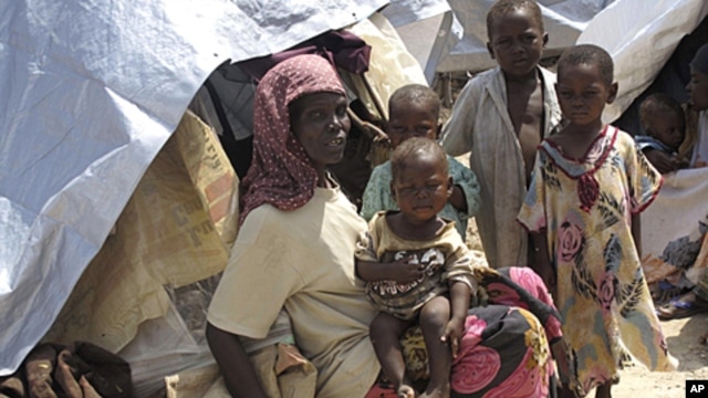 Somalis displaced by famine sit in their makeshift shelters in Mogadishu, Somalia, Friday, July 22, 2011