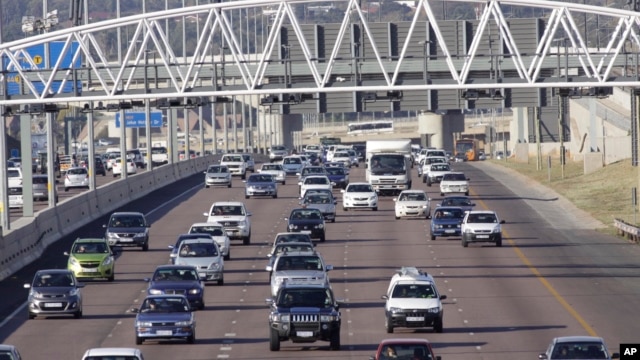 Cars stream underneath a gantry on a road to Pretoria, South Africa, May 4, 2012.  