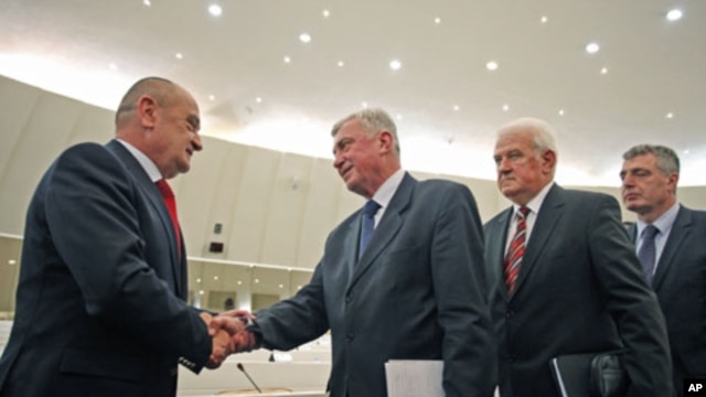 Bosnia's new Prime Minister Vjekoslav Bevanda (L) receives congratulations from members of parliament, in Sarajevo, January 12, 2012.