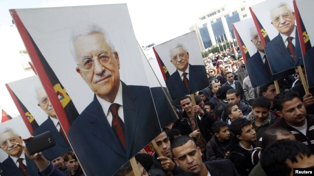 Palestinians hold placards of President Mahmoud Abbas during a rally in support of his efforts to secure a diplomatic upgrade at the United Nations, Ramallah, West Bank, November 25, 2012.