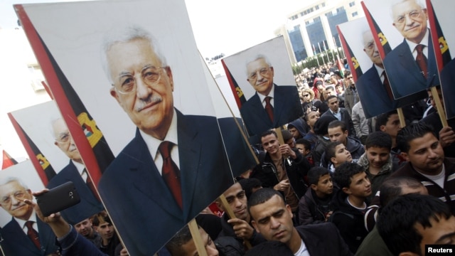 Palestinians hold placards depicting President Mahmoud Abbas during a rally in support of his efforts to secure a diplomatic upgrade at the United Nations, in the West Bank city of Ramallah, November 25, 2012.