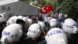 Turkish riot police try to stop ethnic Uighurs from marching to the Chinese Consulate during a protest against China, in Istanbul, Turkey, July 21, 2011.