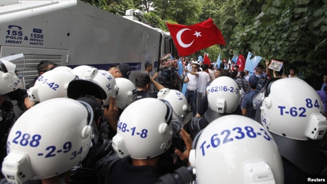 Turkish riot police try to stop ethnic Uighurs from marching to the Chinese Consulate during a protest against China, in Istanbul, Turkey, July 21, 2011.