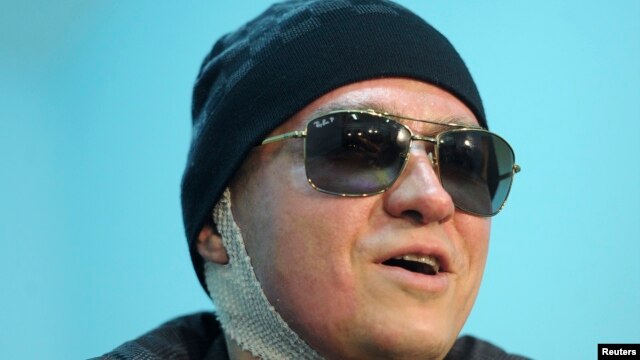 Sergei Filin, artistic director of Russia's Bolshoi Ballet, speaks to journalists as he leaves a hospital in Moscow, February 4, 2013.