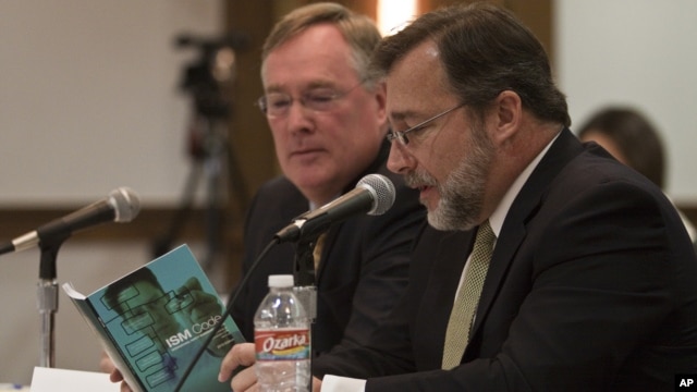 Attorney Tim Johnson, left, and Jerry Canducci, right, Transocean ISM manager, read a ISM Code booklet at the request of the hearing panel at the sixth session of BP oil spill hearings in Houston, December 9, 2010.