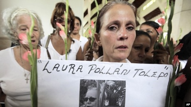 A member of the Ladies in White holds a picture of leader Laura Pollan, inside a church after a march in homage of Laura Pollan, along the main avenue of the upscale Havana district of Miramar in Havana, October 16, 2011.