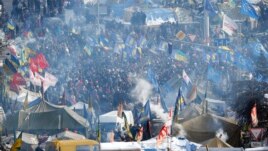 Smoke from cooking fires rise over the tent camp of pro-European Union activists on Independence Square in Kyiv, Ukraine, Sunday Jan. 26, 2014.