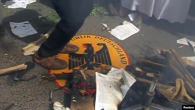 En una imagen tomada de video, un manifestante salta sobre el emblema de la embajada de Alemania en Jartum, capital de Sudán.