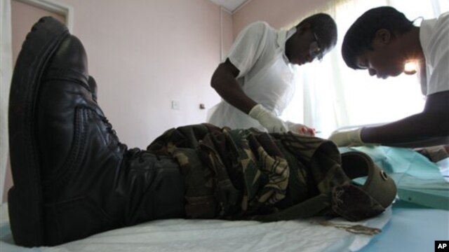 In this Oct. 28, 2010 photo, a doctor and a nurse perform a circumcision procedure on a Zimbabwean soldier at a local clinic in Harare, Zimbabwe. The U.S. Agency for International Development is leading a war on AIDS that may help save hundreds of thousan