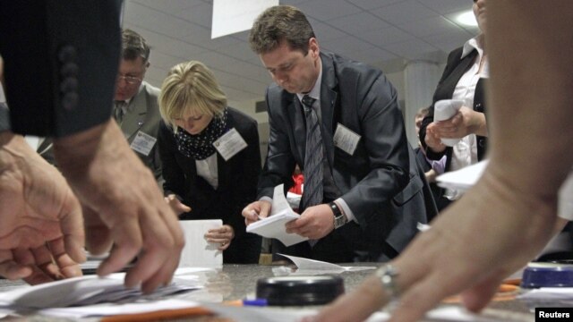 Members of the local electoral commission count ballots at a polling station after the parliamentary election in Minsk, Belarus, September 23, 2012.