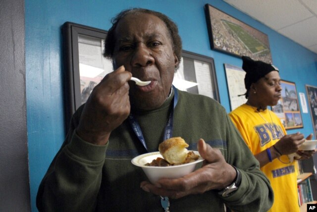 Billie Pollard, left, and Robert Howard try the cassoulet from the Sanford Restaurant at the Guest House, a Milwaukee homeless shelter, Dec. 8, 2015.