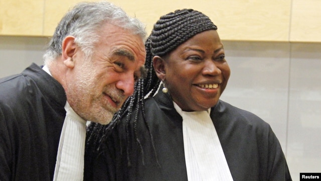 Newly sworn-in ICC prosecutor Fatou Bensouda shares a laugh with her predecessor Luis Moreno-Ocampo (L) at the ICC, The Hague, Netherlands, June 15, 2012. 