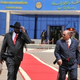 Sudanese President Omar al-Beshir (R) walks with Sudan's First Vice President and south Sudan leader Salva Kiir at the airport in Khartoum, as he prepares to leave for Chad, 21 Jul 2010
