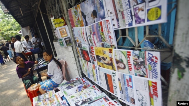 A girl selling weekly journals waits for customers in Rangoon, Burma, April 2, 2012. 