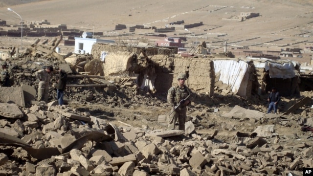 A U.S. soldier stands guard at the site of suicide attack in Wardak Province of Kabul Afghanistan, Friday, Nov, 23, 2012. 