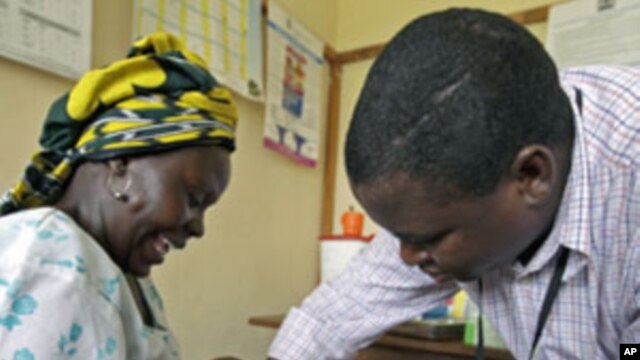 Iren Salama (L) holds her baby Pendo as it is given an injection as part of a malaria vaccine trial at a clinic in the Kenya coastal town of Kilifi, November 23, 2010 (file photo)