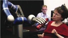 Cathy Hutchinson drinking from a bottle using the robotic arm