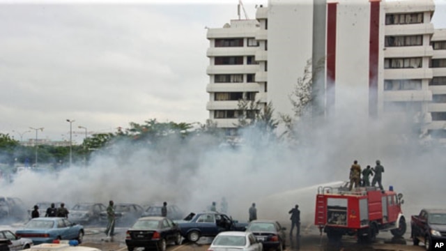Firefighters trying to extinguish a fire after a bomb blast at the parking lot of police headquarters in Abuja, Nigeria, June 16, 2011