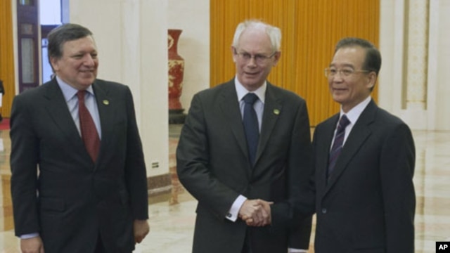 Chinese Premier Wen Jiabao, right, shakes hand with EU President Herman Van Rompuy beside European Commission President Jose Manuel Barroso before their meeting at the Great Hall of the People in Beijing , Feb. 14, 2012.