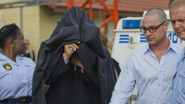 Južnoafrički policajci sprovode Pistorijusa u sudnicu radi prvog pretresa u vezi sa optužnicom za ubistvo