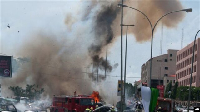 Smoke and debris fill the sky seconds after a car bomb explodes alongside firemen responding to an initial car bomb that had exploded five minutes earlier, in Abuja, Nigeria, 01 Oct 2010