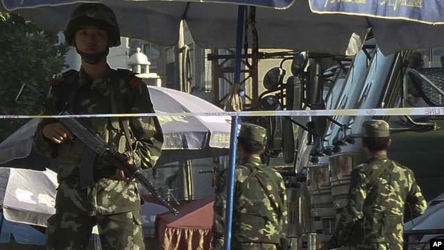 Armed Chinese policemen stand guard on a street in Kashgar in China's far western Xinjiang Uygur Autonomous Region, file photo. 