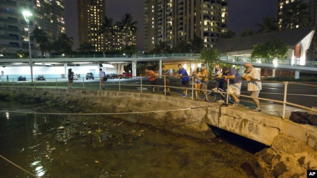 Du khách và cư dân Oahu đứng xem mực nước tại cảng Ala Wai, ngày 27/10/2012