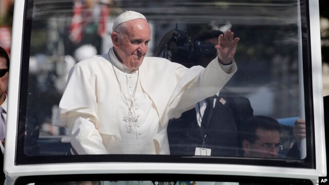 Pope Francis waves to the crowd from the popemobile during a parade in Washington, Wednesday, Sept. 23, 2015.