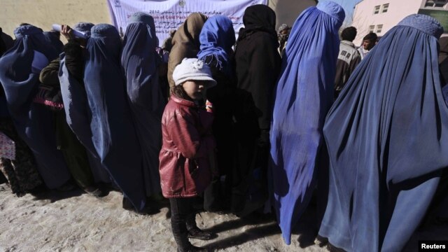 Afghan women line up to receive winter relief assistance donated by the United Nations High Commissioner for Refugees (UNHCR) in Kabul, January 2, 2013. 