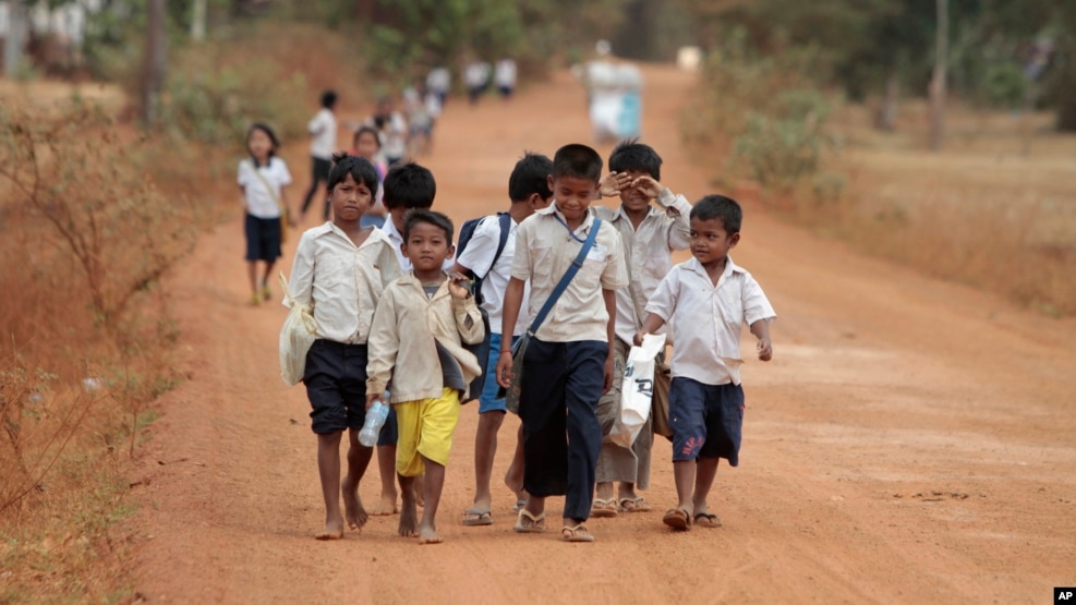 FILE - Cambodian school children walk home after a morning school session at Tnoat Kpoh village in the outskirts of Phnom Penh, Cambodia.