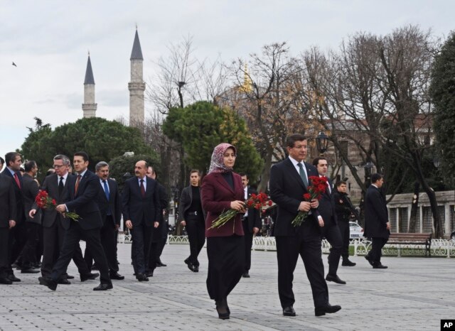 Turkey's Prime Minister Ahmet Davutoglu, right, accompanied by his wife Sare, visit the site of Tuesday's explosion, in the historic Sultanahmet district of Istanbul, Wednesday, Jan. 13, 2016.