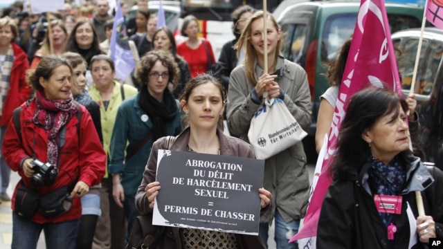 An activist holds a sign as she attends a demonstration a day after the French Constitutional Council decided the immediate repeal of the law on sexual harassment, in Paris, May 5, 2012.  