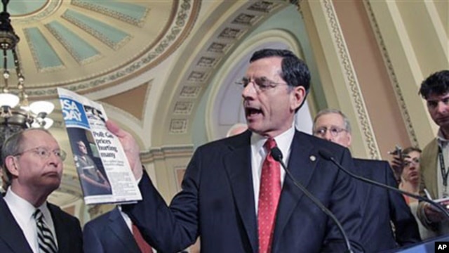Sen. John Barrasso [C] quotes a USA Today article about gas prices as he and Sen. Lamar Alexander [L] and Senate Republican leader Mitch McConnell [R] speak to reporters, at the Capitol in Washington, D.C., May 17, 2011