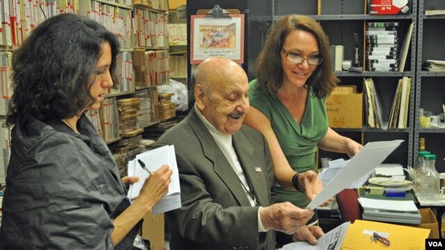 Leo Sarkisian and Heather Maxwell (right), the host of VOA's "Music Time in Africa," look over listener mail in the library that houses his vast collection of African music. Looking on is Washington Post reporter Tara Bahrampour.