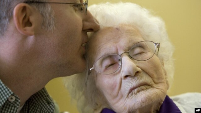 Besse Cooper receives a kiss from her grandson during a Guinness World Records ceremony in Monroe, Ga, March 10, 2011. 