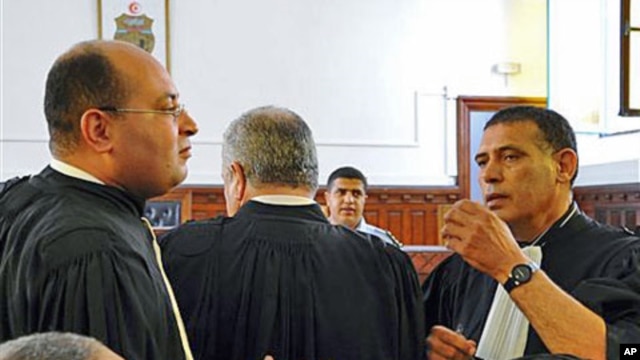 Former Tunisian President Zine El Abidine Ben Ali's lawyers Hosni Beji (L) and Abdsatar Messaoudi talk as the second trial of Tunisia's former president opened in Tunis, July 4, 2011