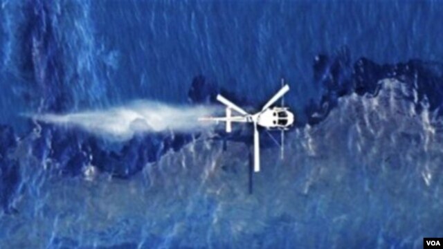 Un helicópero arroja dispersante sobre la mancha de petróleo que ha dejado el derrame del barco liberaino Rena en Nueva Zelanda.