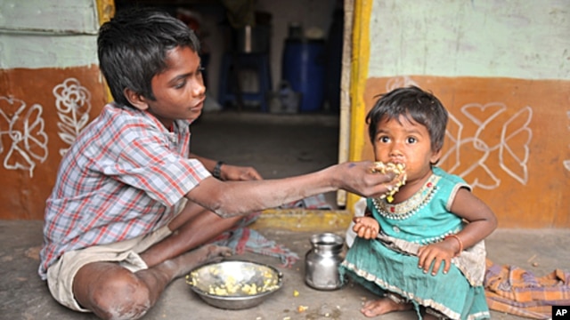 An Indian boy feeds his sister at their home in a slum in Hyderabad.  Levels of under-nutrition in the country were "unacceptably high" despite impressive GDP growth, Prime Minister Manmohan Singh said Tuesday and added that the problem of malnutrition wa