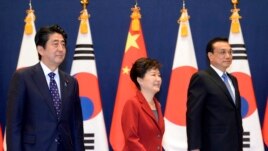 Japan's prime minister and South Korea's president appear with Chinese Premier Li Keqiang, right, during the trilateral summit in Seoul, South Korea.