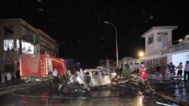 Firefighters hose down a vehicle after an explosion in front of  the central Hadayeq police station in Benghazi, Libya, November 4, 2012. 