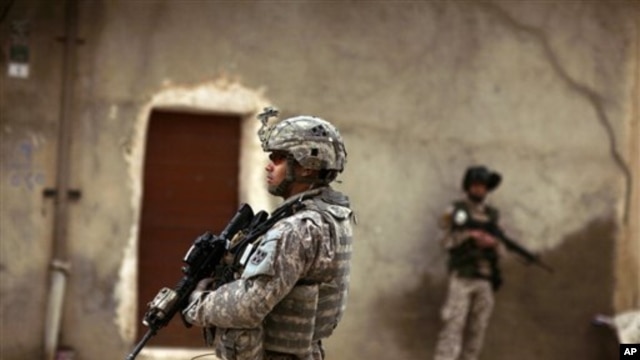 An Iraqi Army soldier and a U.S. Army soldiers from Delta Co., 1st Combined Arms Battalion, 67th Armor Regiment stand guard during a joint patrol in Mosul, Iraq, March 2009 (file photo)