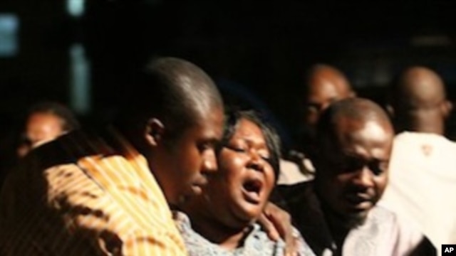 A woman who lost a relative in a bomb explosion, center, mourns at the Asokoro General Hospital, Abuja, Nigeria, 31 Dec 2010