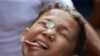 A boy attempts to move a coin into his mouth during a celebration of the patron saint Santa Rita de Cascia in Baclaran, Paranaque city, metro Manila, Philippines.