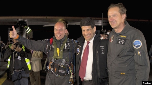 The Solar Impulse plane's project president and pilot, Bertrand Piccard (L) celebrates with co-founder and CEO Andre Borschberg (R) and Moroccan Agency for Solar Energy (MASEN) CEO Mustapha Bakkoury after the plane landed following a 19-hour flight from M