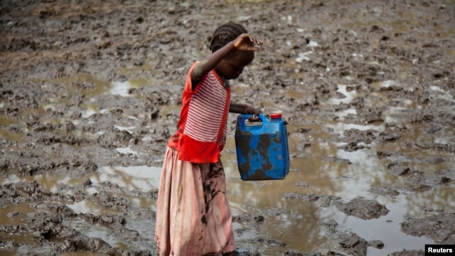 A girl walks through mud to get water at the Yusuf Batil refugee camp in Upper Nile, South Sudan, July 4, 2012.