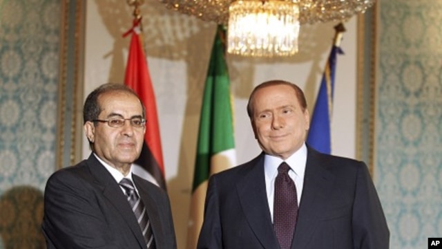 Italian premier Silvio Berlusconi, right, shakes hand with Mahmoud Jibril, deputy chairman of the Libyan National Transitional Council, at the prefecture building in Milan, Italy, August 25, 2011