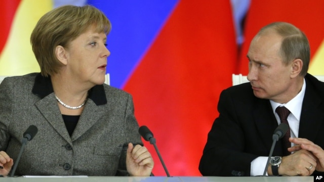 Russian President Vladimir Putin, right, and German Chancellor Angela Merkel speaks to each other after a signing ceremony during a Russian-German business forum in the Grand Kremlin Palace in Moscow, Friday, Nov. 16, 2012.